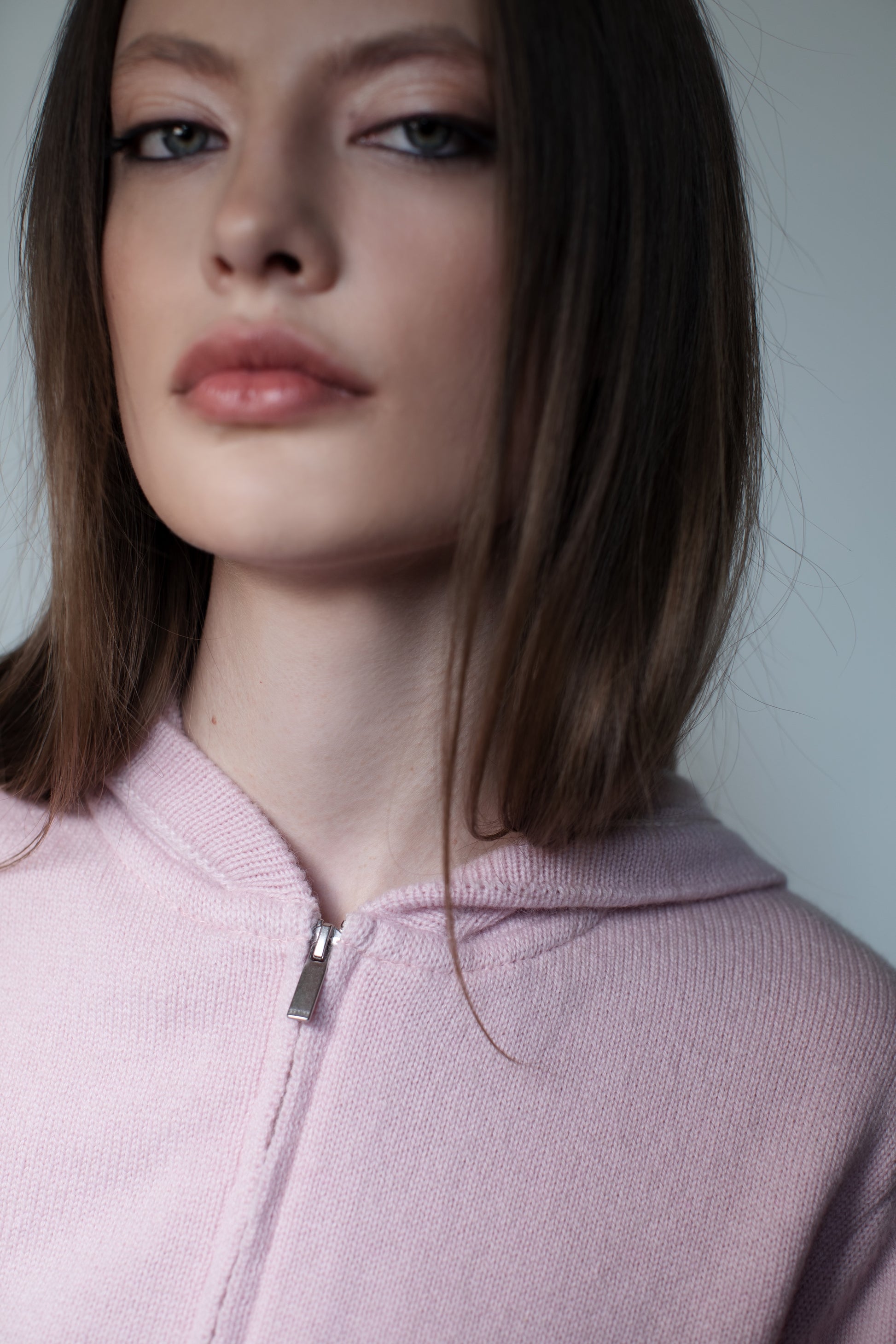 Close-up of soft pink cashmere zip hoodie with silver zipper and fine knit texture.  - farbe-rosa