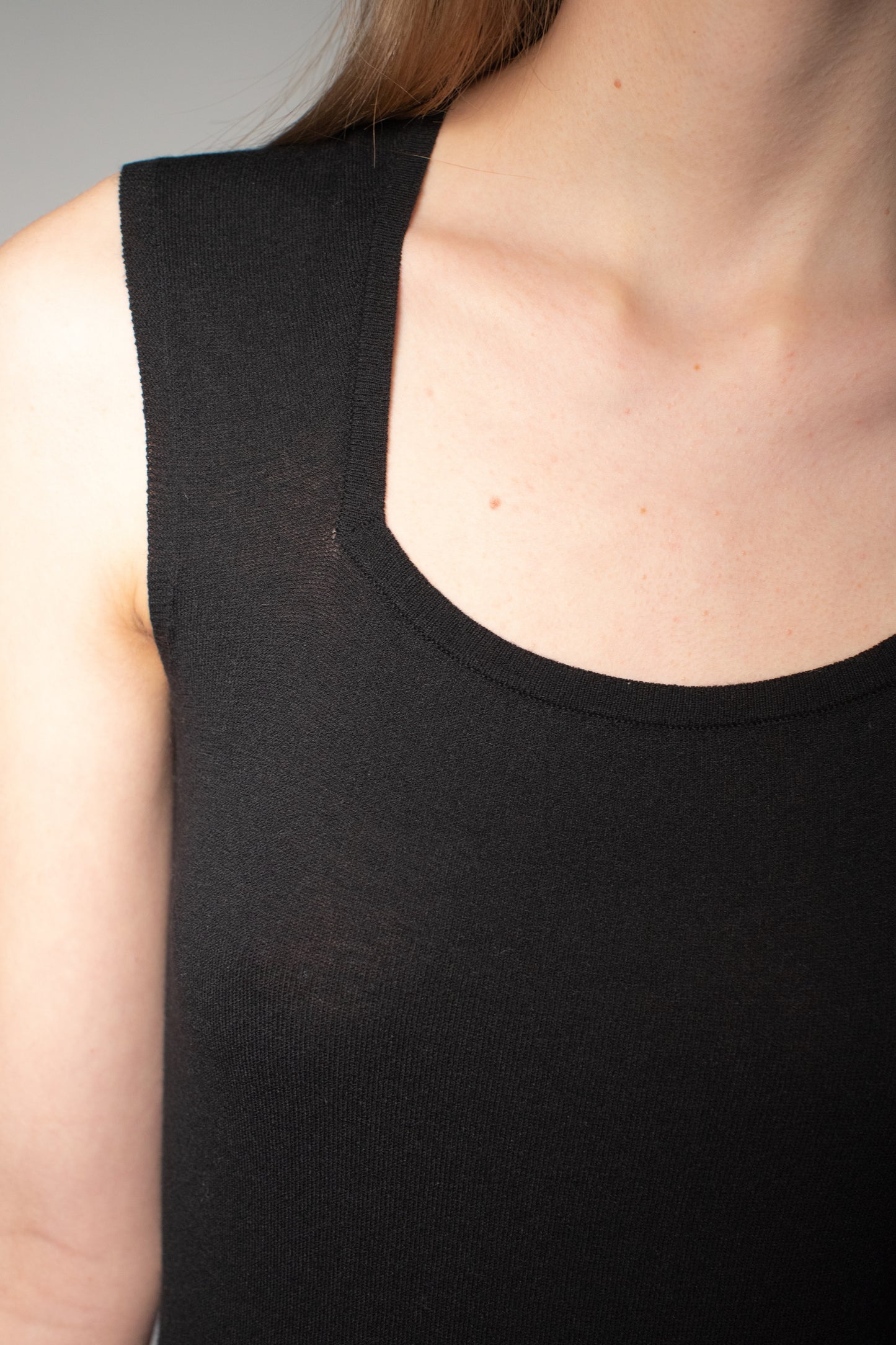 Close-up detail of black knit bodysuit neckline and fine knit texture. farbe schwarz
