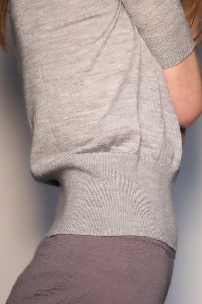Detail of the CORINN seamless silk wool knit T-shirt showing the wide ribbed waistband and fine knit texture. farbe-grau - melange
